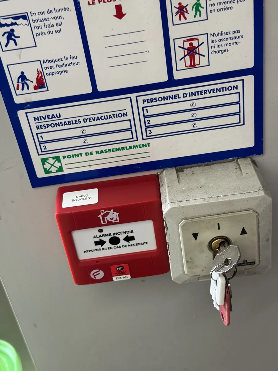 Déclencheur manuel d'alarme posé près d'une issue